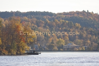 Docks on Gatineau river and houses by the hill near Wakefield