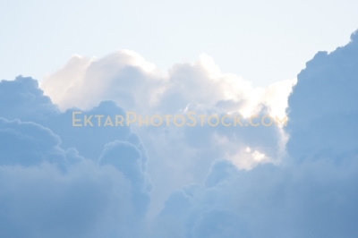 Puffy clouds highlighted by sun in the sky  18163
