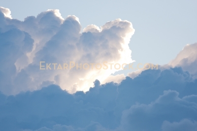 Puffy clouds highlighted by sun in the sky