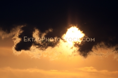 Puffy dark clouds highlighted by sun in the sky